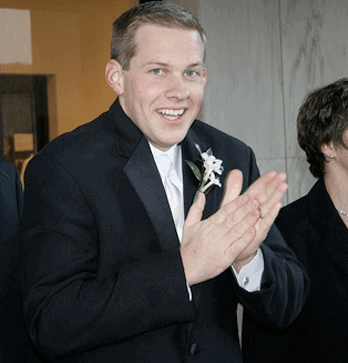 Gordon in a suit rubbing his hands together