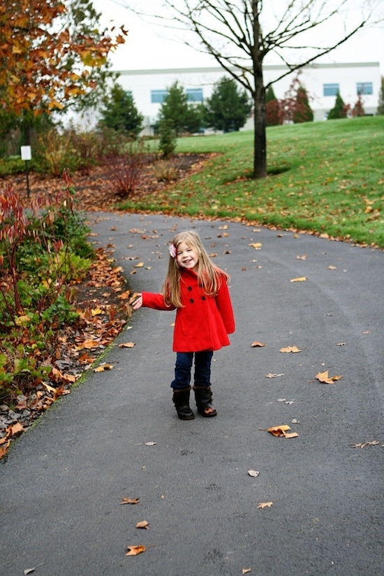 A little girl standing on a sidewalk