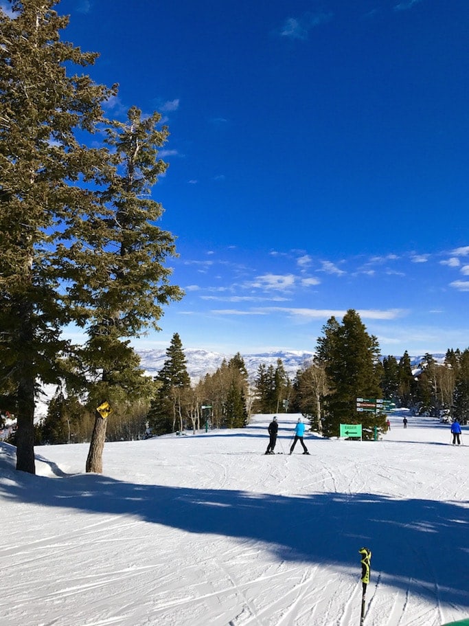 A person riding skis down a snow covered slope