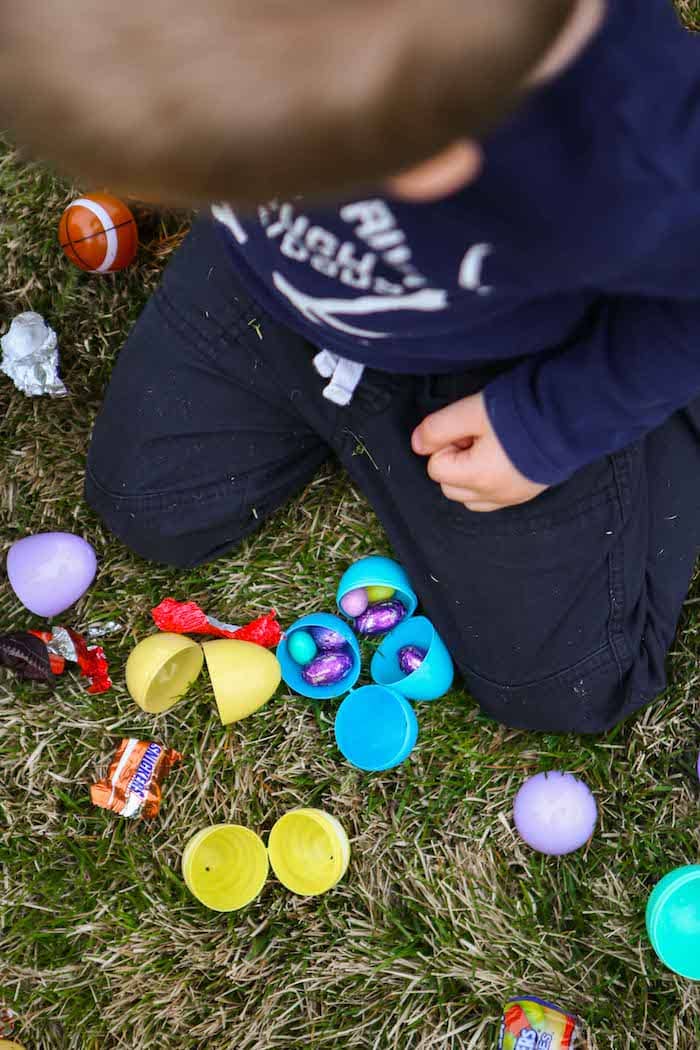 A kid sitting on the grass with Easter eggs
