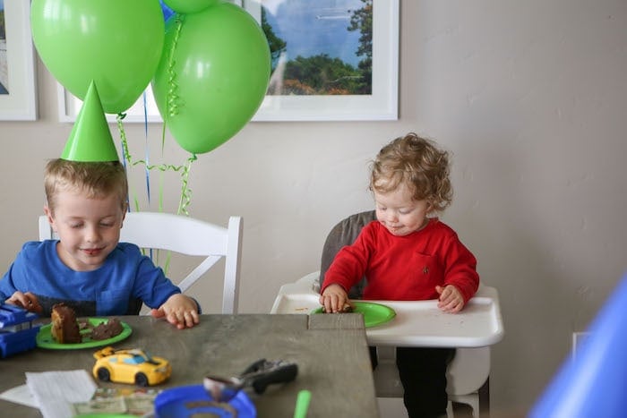 Eddie in a high chair eating cake