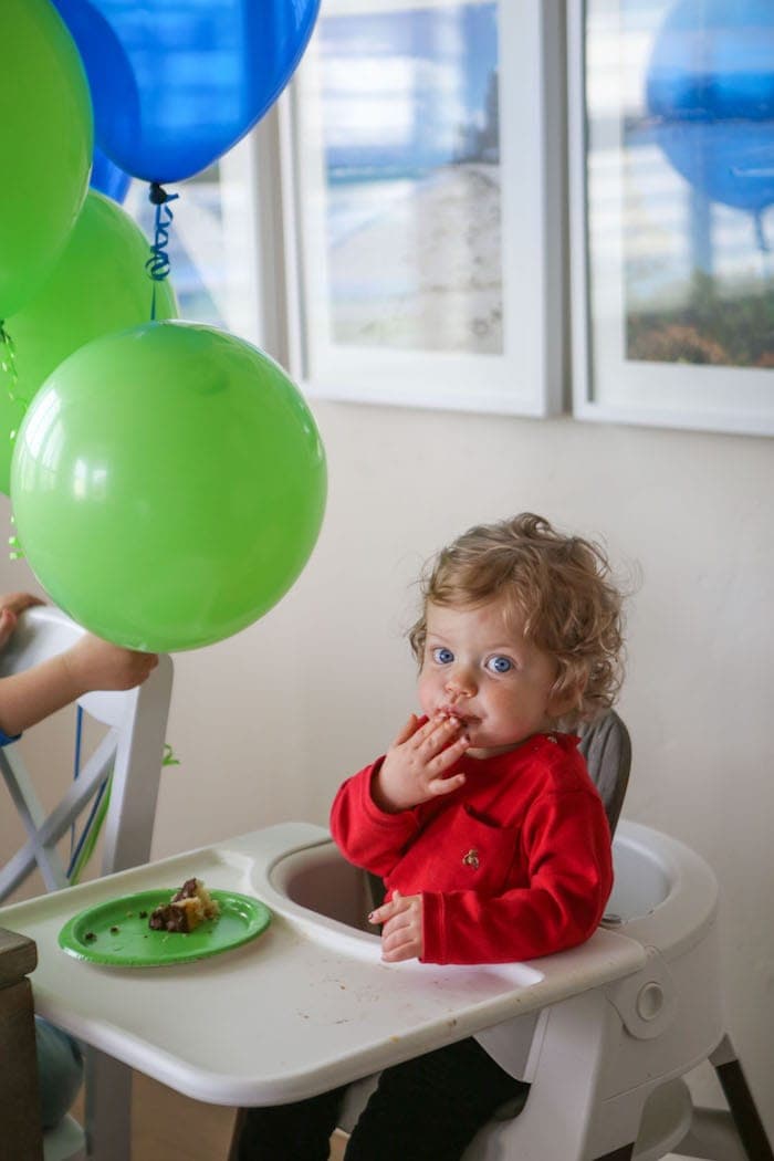Eddie in a high chair eating cake