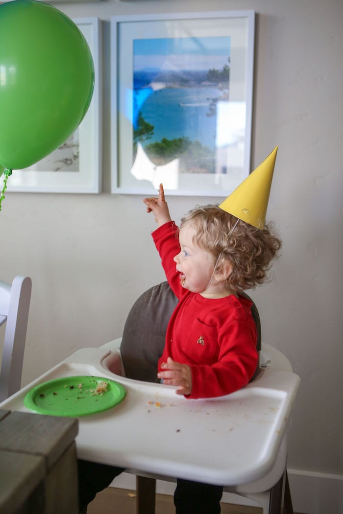 Eddie in a high chair eating cake