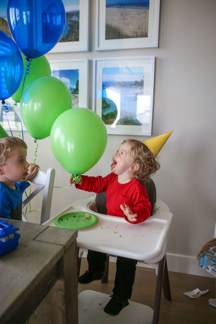 Eddie in a high chair holding a balloon