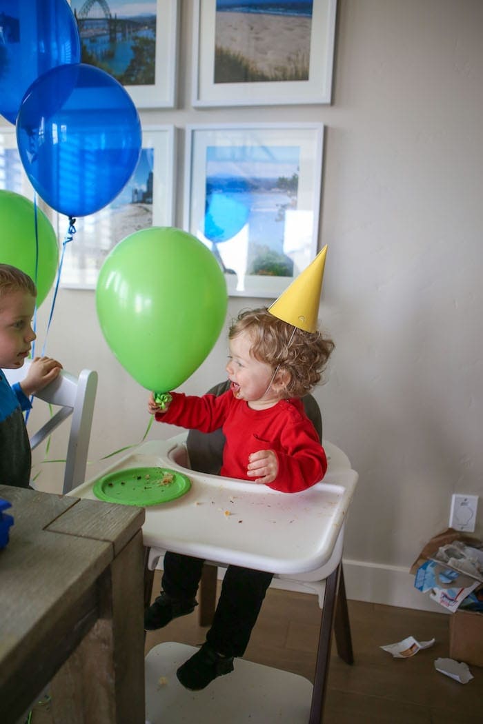 Eddie in a high chair holding a balloon