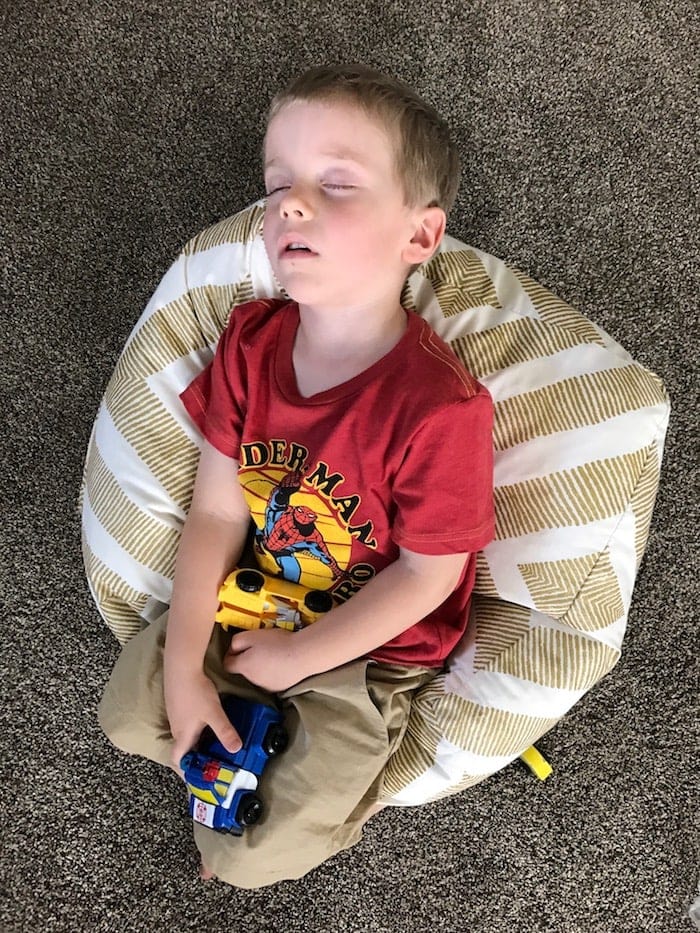 Blake asleep on the ground holding toys