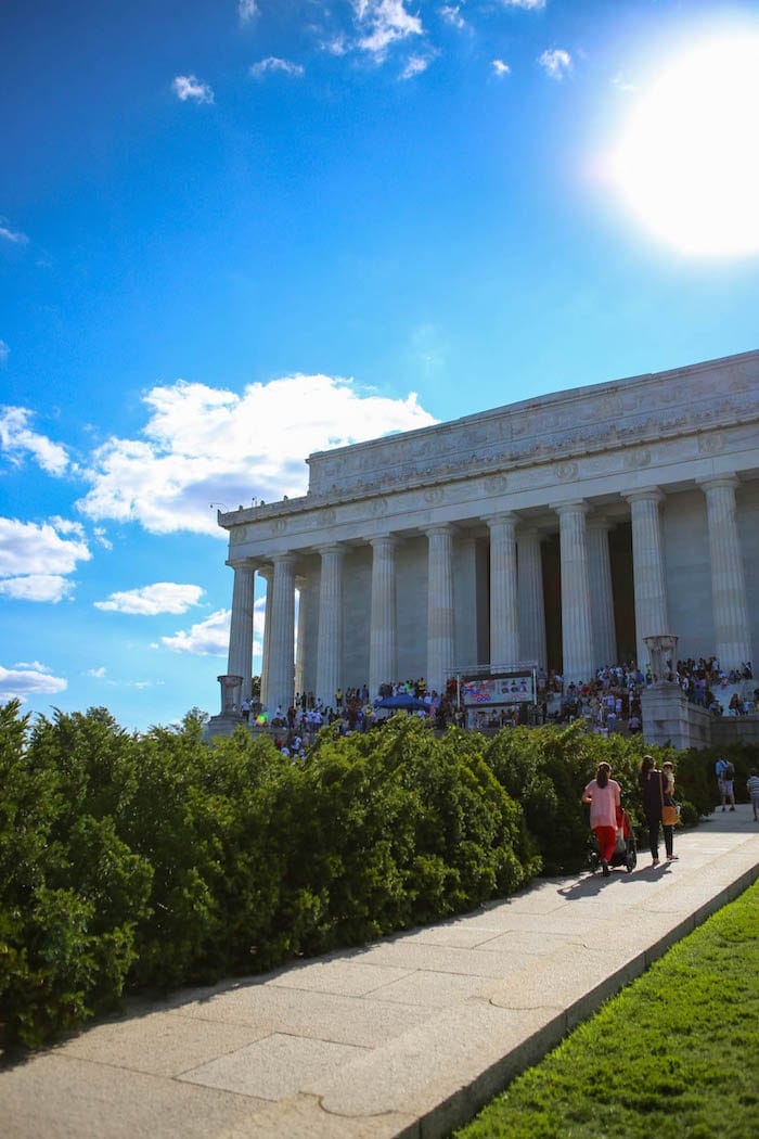 A person standing in front of a building, with Lincoln Memorial