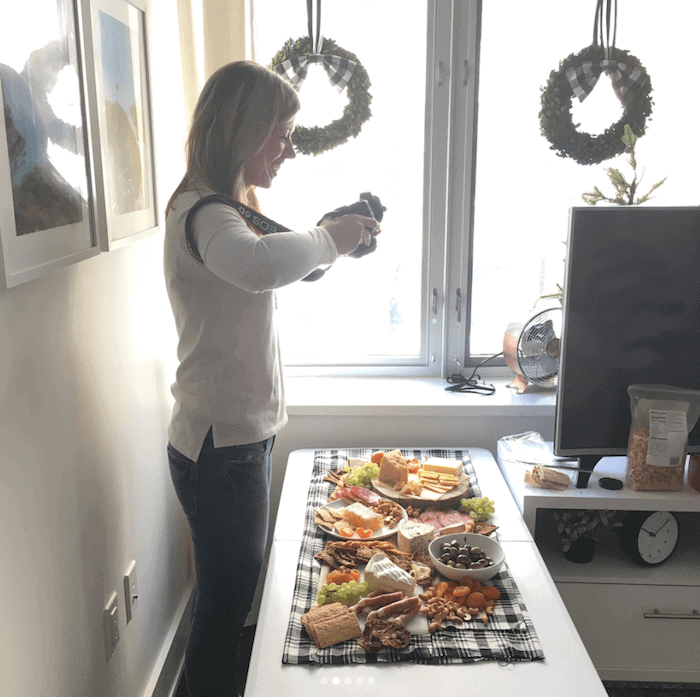 Lauren taking pictures of a cheeseboard