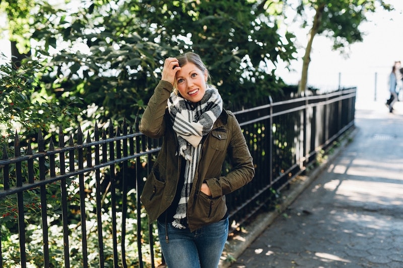 A person standing in front of a fence