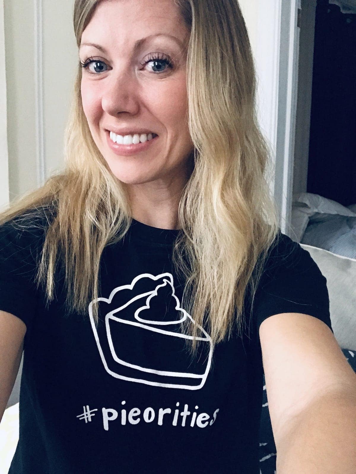 Lauren smiling for the camera wearing a pie shirt