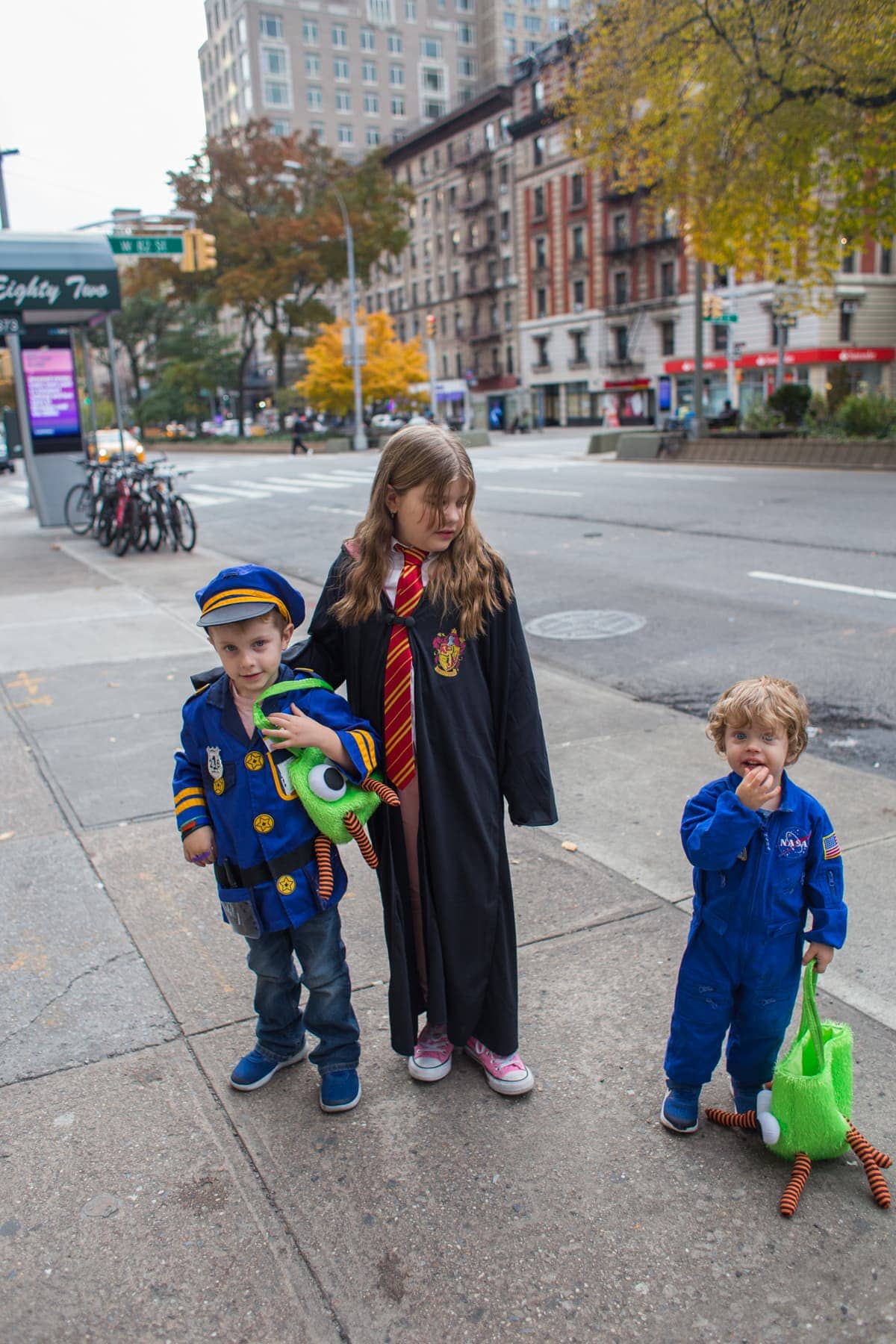 The kids dressed for Halloween on the sidewalk