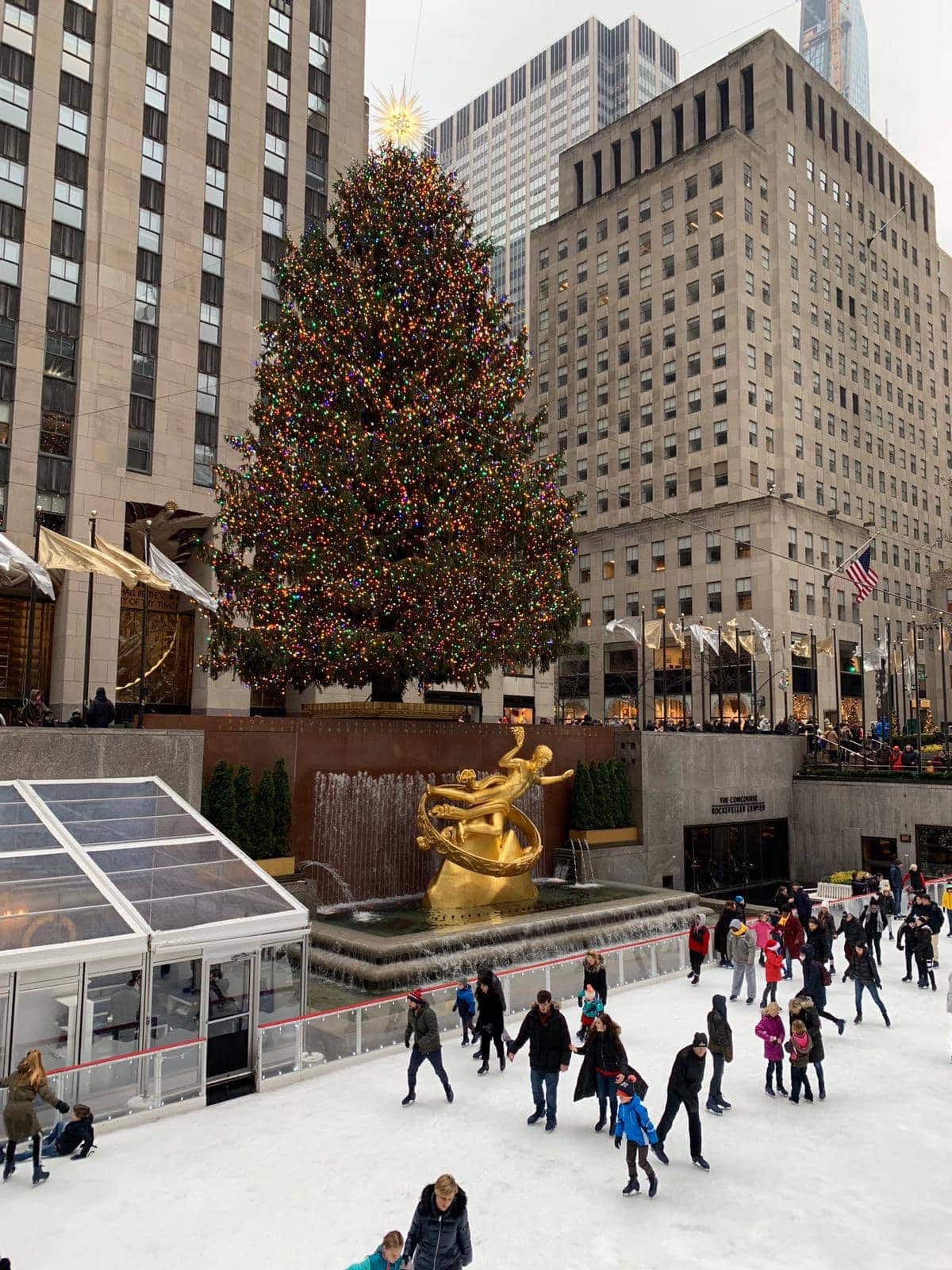 A group of people ice skating Rockefeller Center