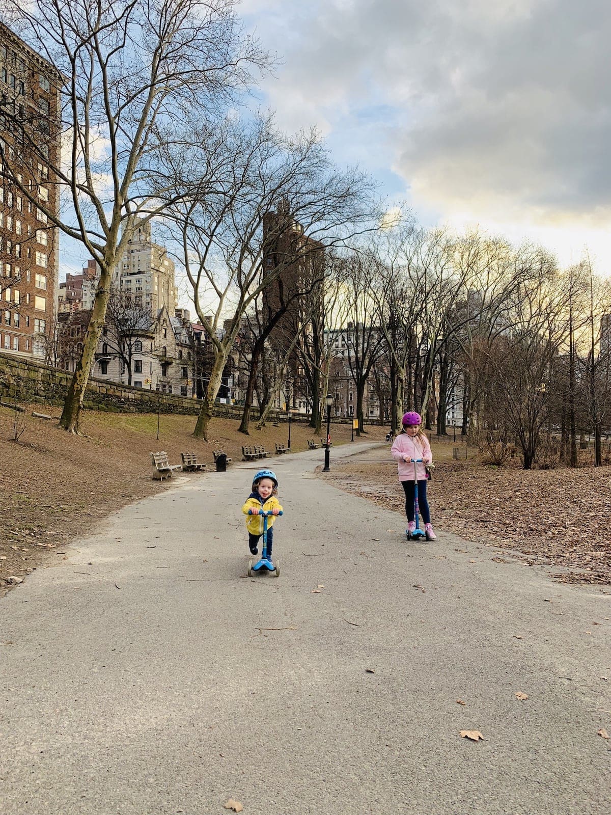 The kids scootering down a path