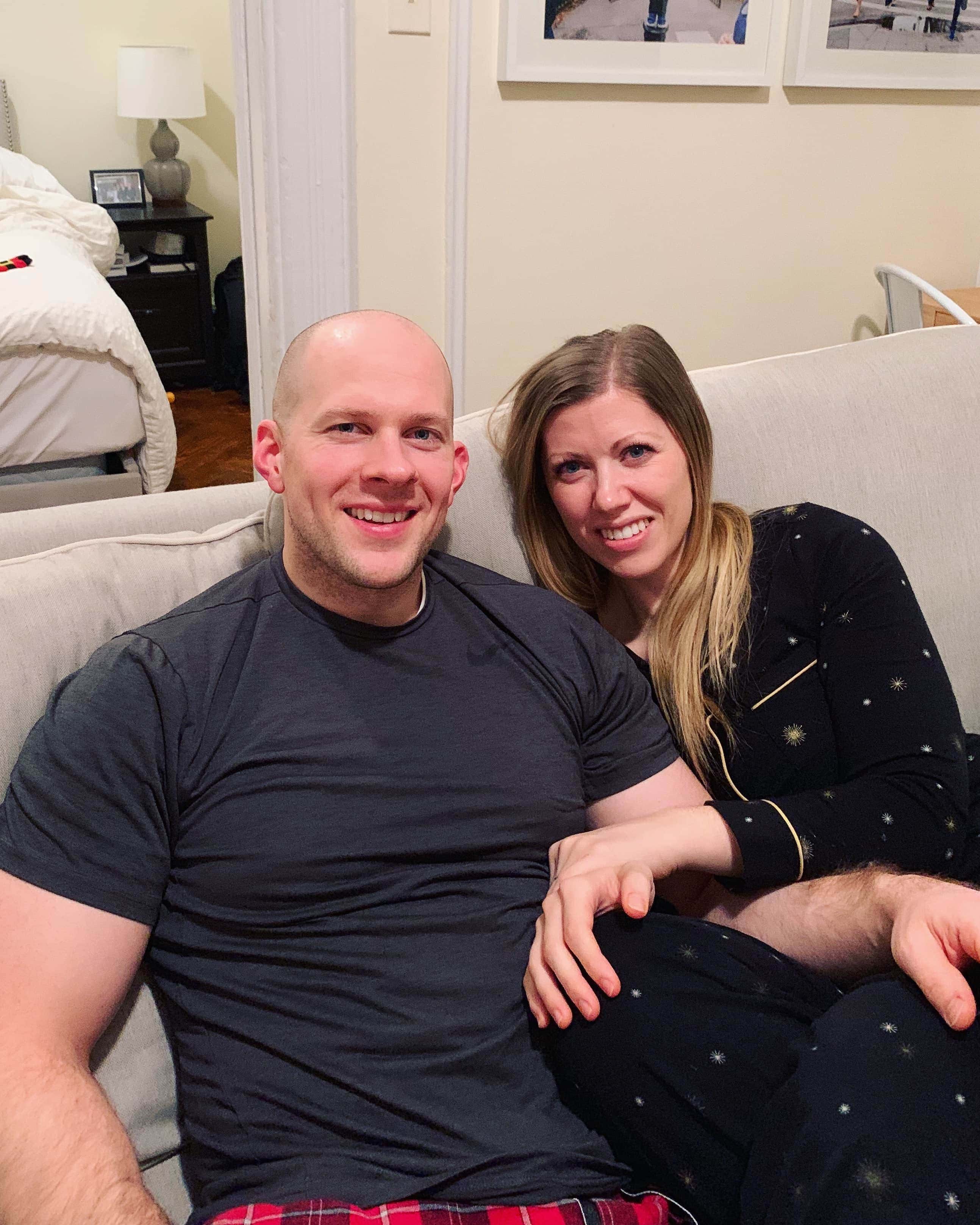 A man and a woman sitting on a couch posing for the camera