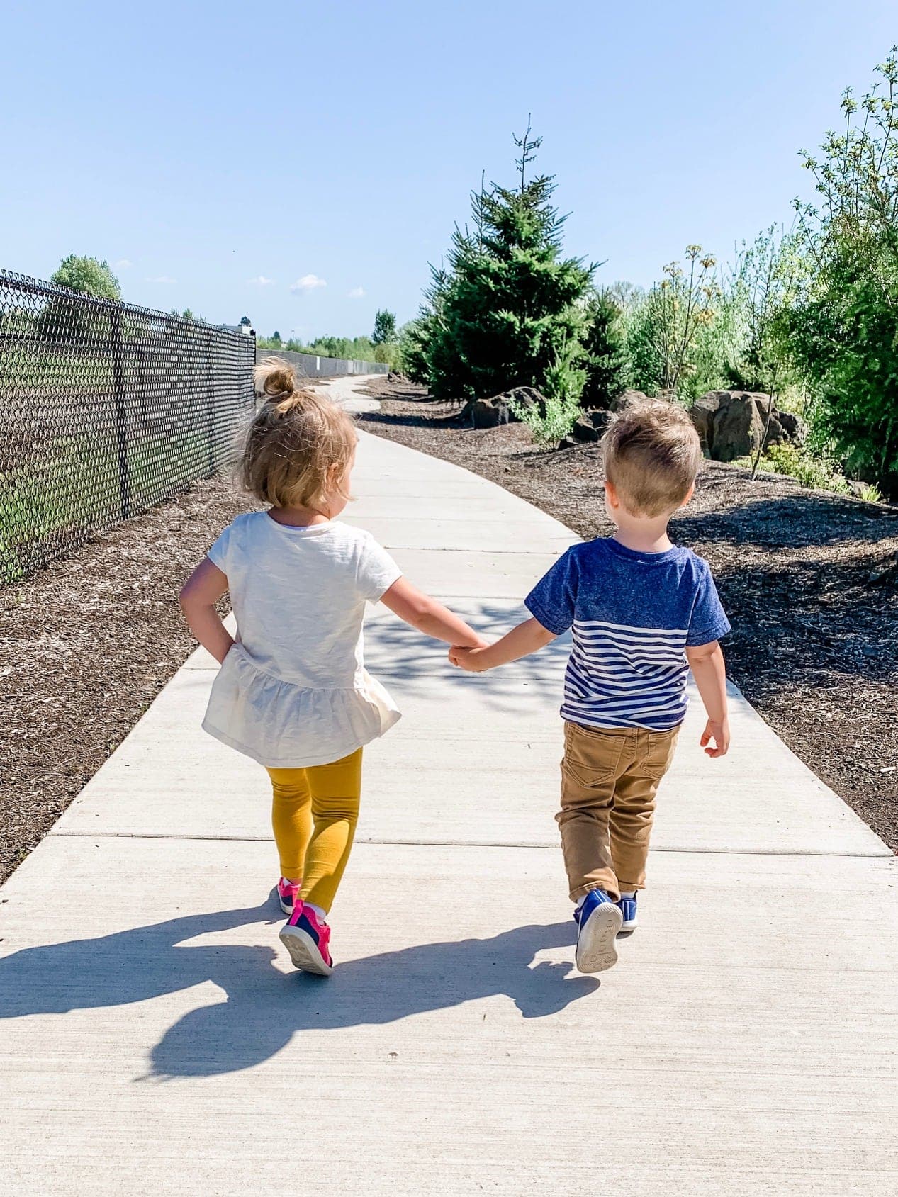 Eddie holding hands with a friend walking down a path