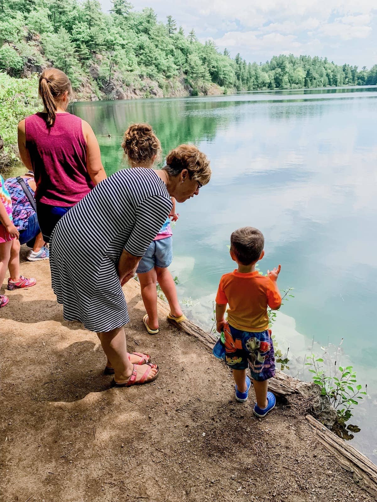 A group of people standing next to a body of water