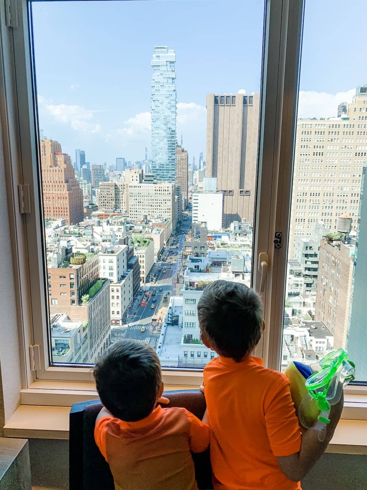 The boys looking outside a window to the city