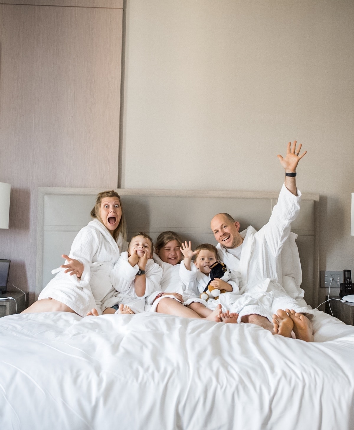 Brennan family in robes on a bed making silly faces