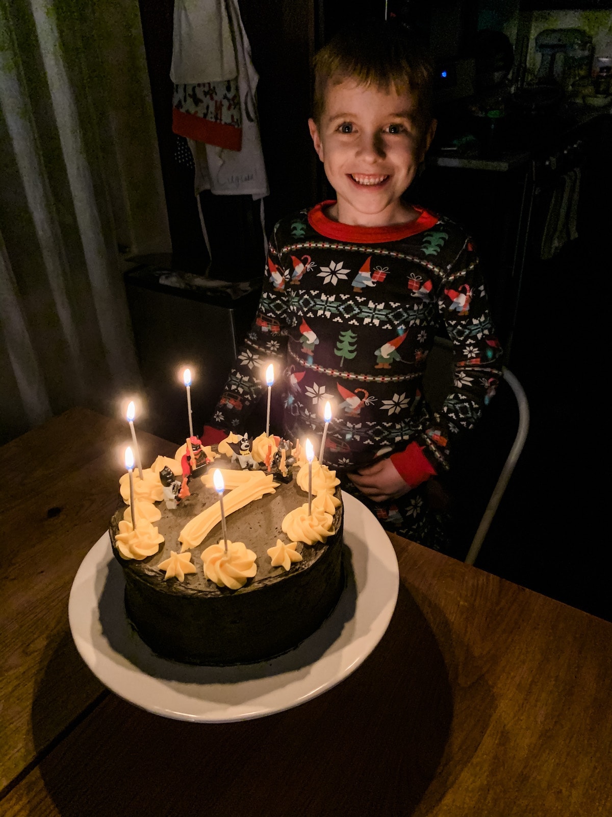 Blake sitting in front of a birthday cake with lit candles