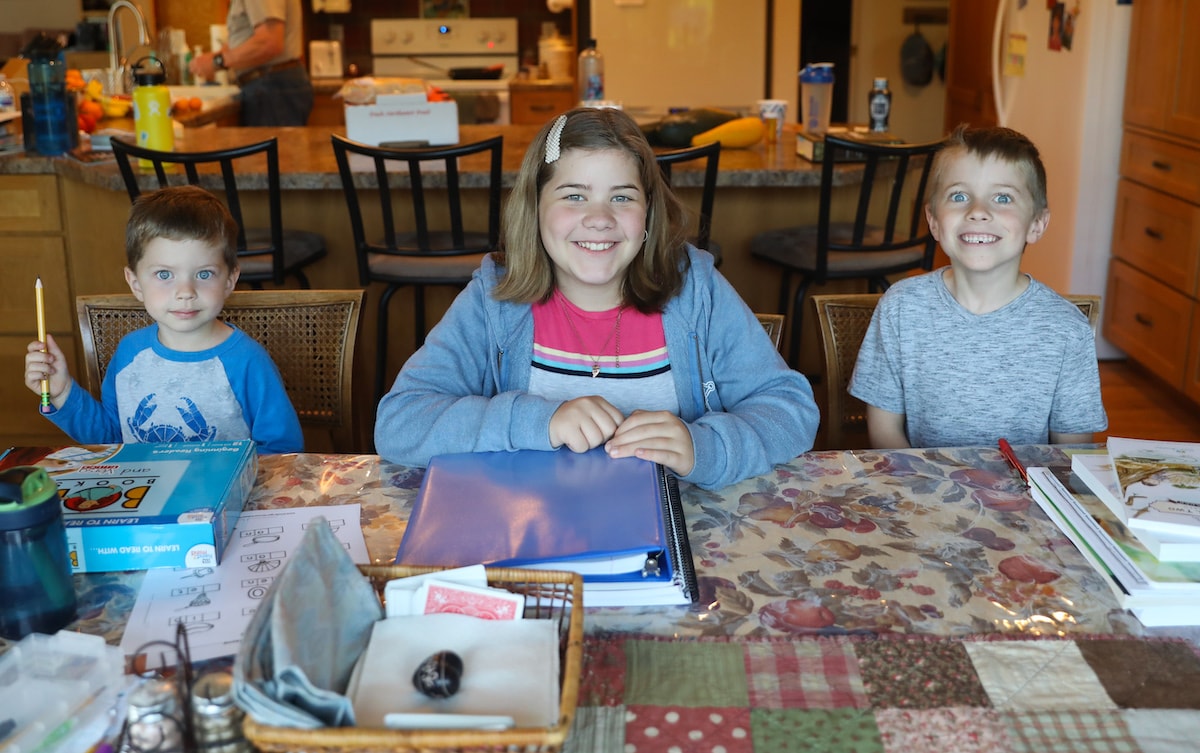 three kids sitting at a table