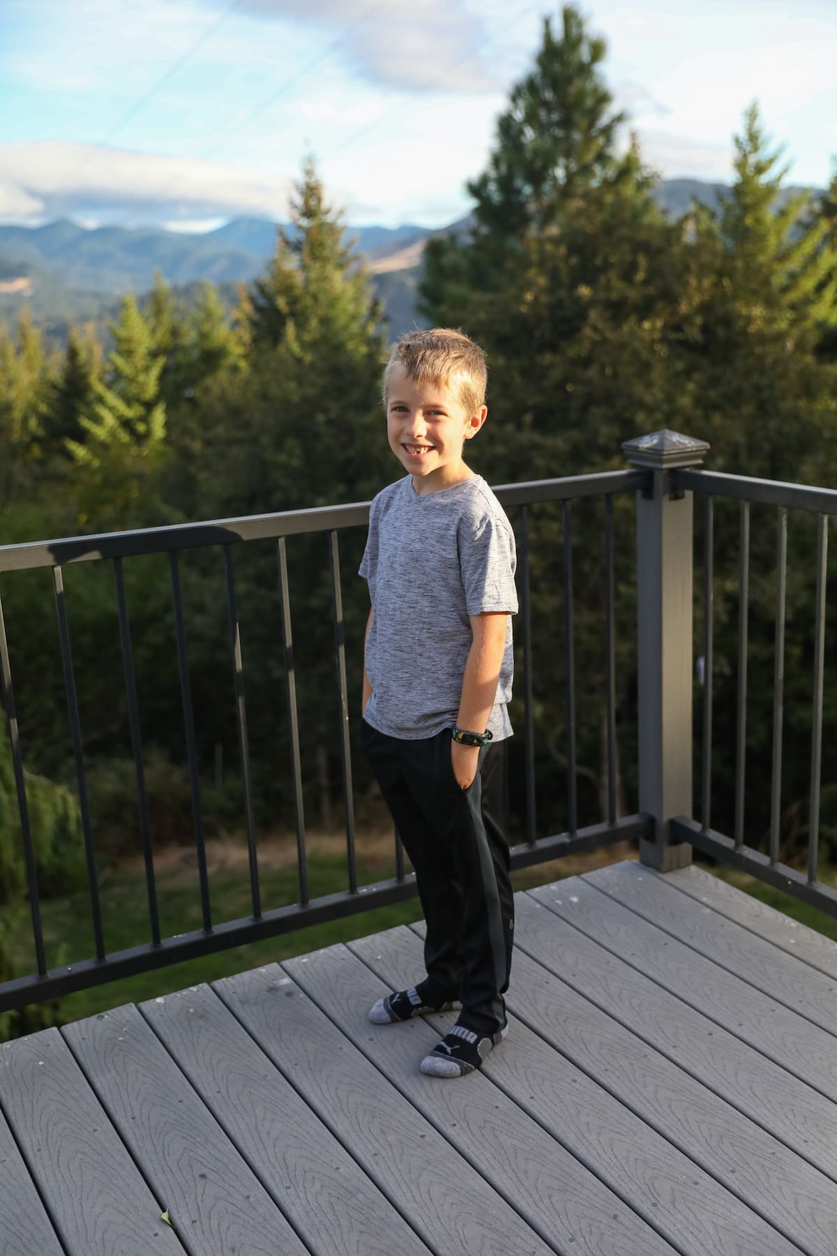 boy smiling with hands in his pockets