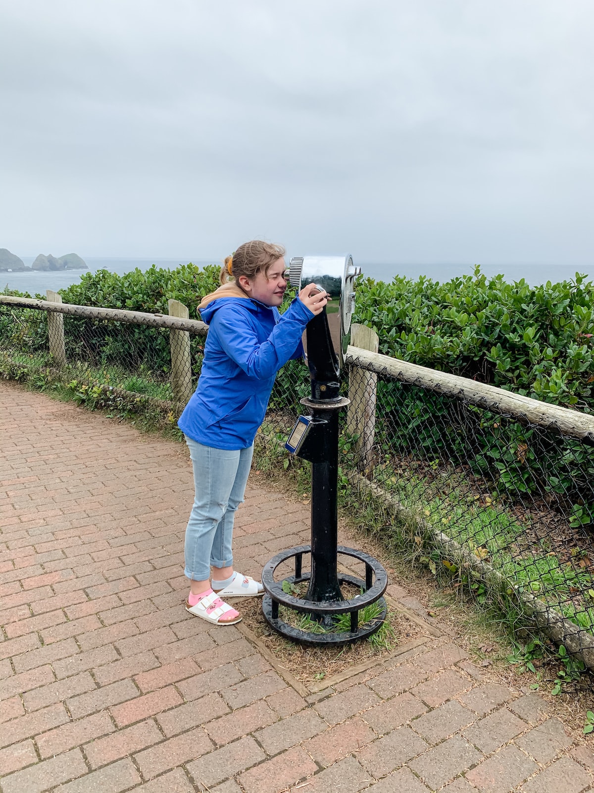 girl looking through coin operated binoculars
