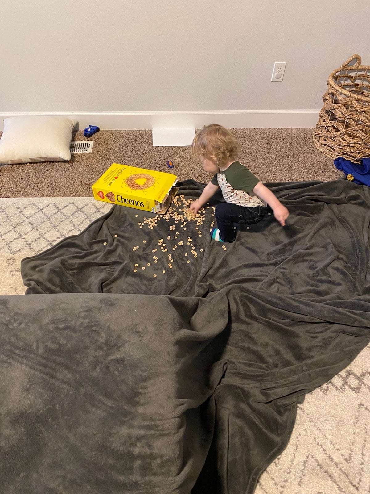 baby with dumped cheerios on blanket