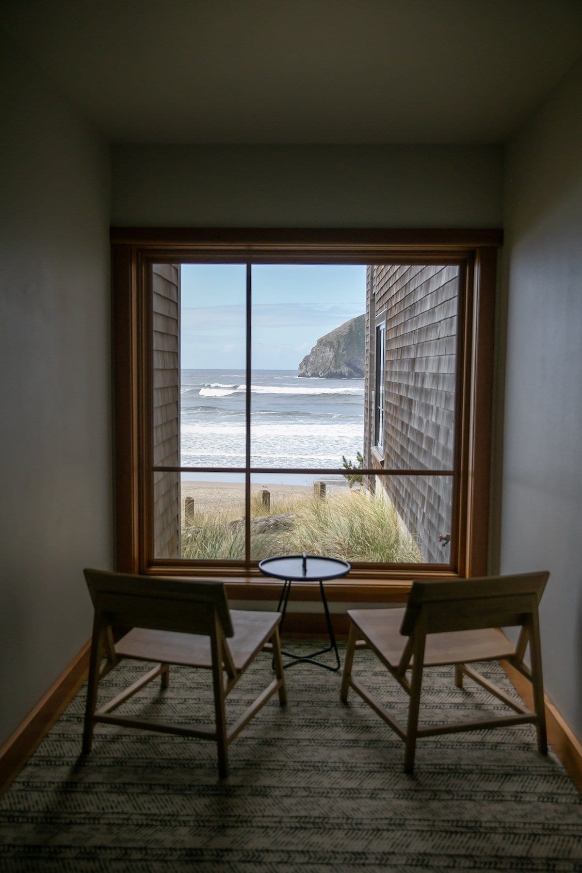 two chairs facing a window of beach