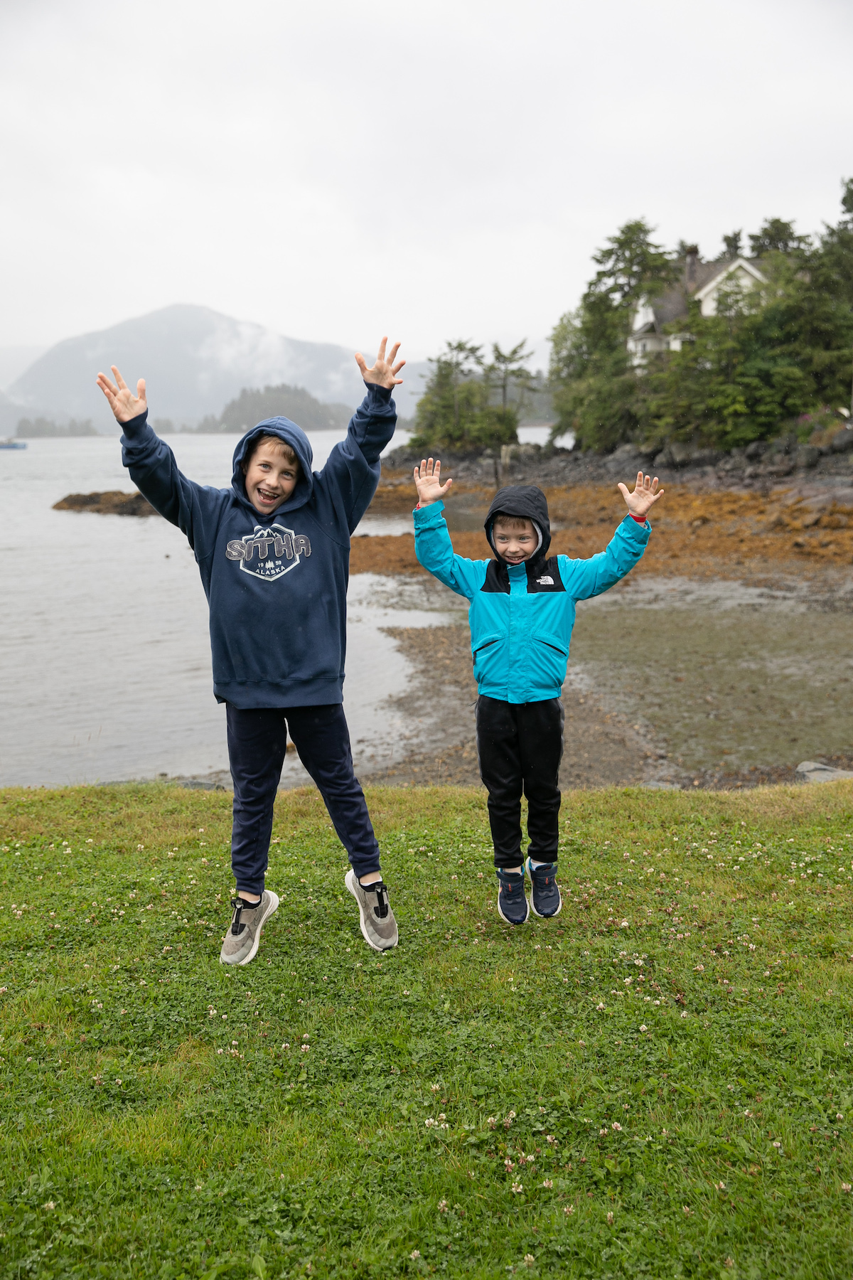 two boys jumping in the rain